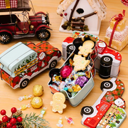 Decorative tins with candy and Christmas-themed items on a wooden surface
