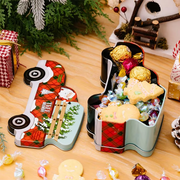 Decorative tins filled with candies on a wooden surface with Christmas decorations.