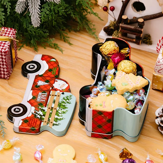 Decorative tins filled with candies on a wooden surface with Christmas decorations.