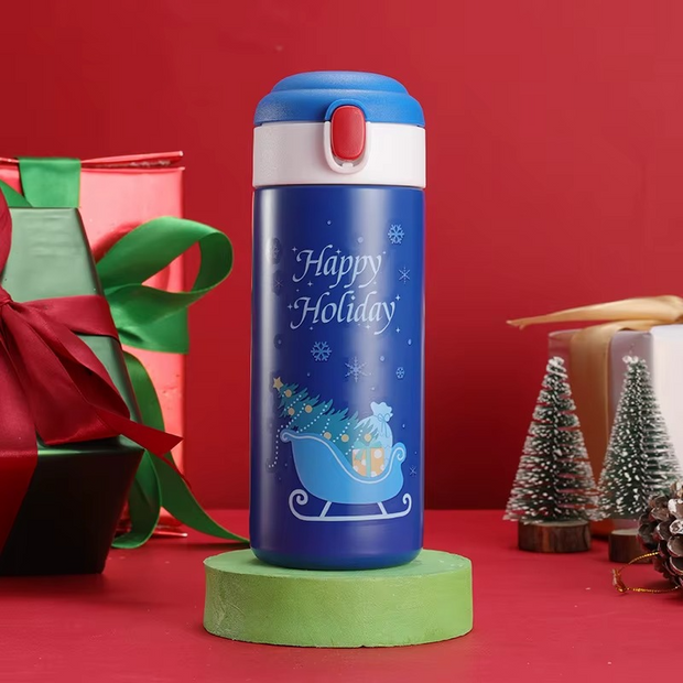 Colorful holiday thermos bottles displayed with Christmas decorations