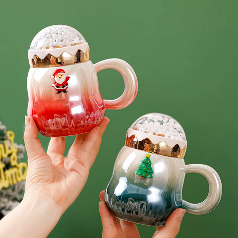 Christmas snow globe ceramic mugs with Santa and Christmas tree designs held in hands